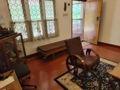 a living room with a chair and a bench at Deshadan's Kesarvilla in Palakkad