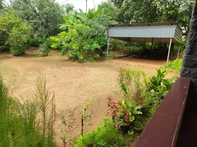 a bench sitting in a garden with a building at Deshadan's Kesarvilla in Palakkad