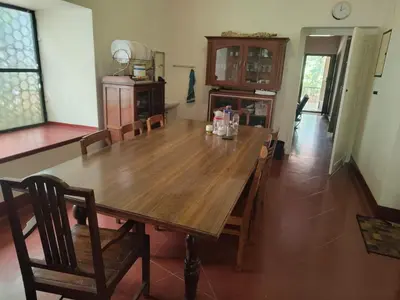 a dining room with a wooden table and chairs at Deshadan's Kesarvilla in Palakkad