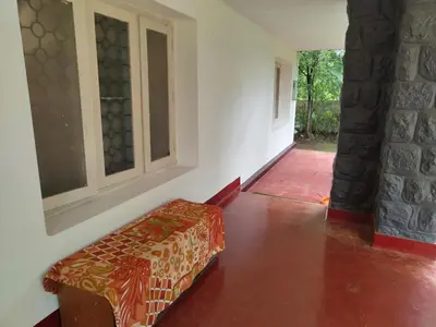 a room with a bench in the middle of a room at Deshadan's Kesarvilla in Palakkad