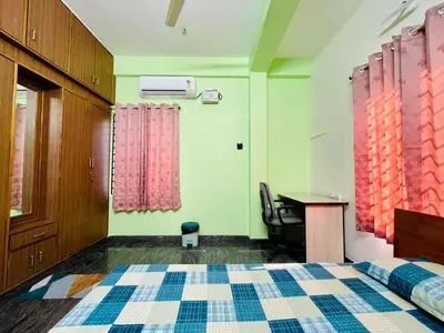 a bedroom with a bed and a desk and a desk at Anand's Elegant 2BHK Apartment - AC in Mysore