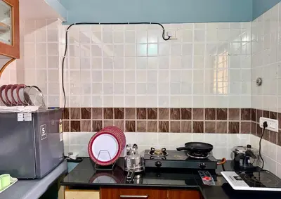 a kitchen with a stove and a sink with a mirror at Anand's Elegant 2BHK Apartment - AC in Mysore