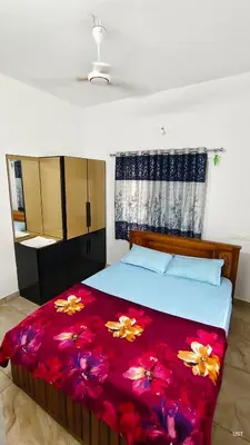 a bedroom with a bed with a red blanket at Happy Homes in Palakkad