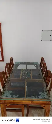 a glass table with two chairs around it at Happy Homes in Palakkad