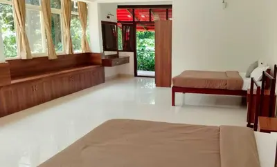 a bedroom with a bed and windows in a room at Hermitage in Kurchi