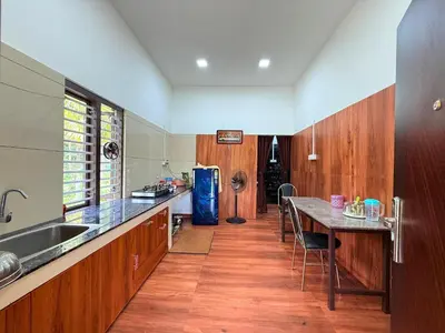 a kitchen with a table and a counter top at Horegallu Homes in Agali
