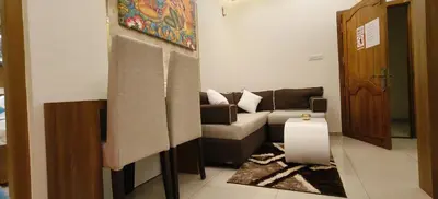 a living room with a couch and a table at Radha Madhavam Apartment's in Guruvāyūr