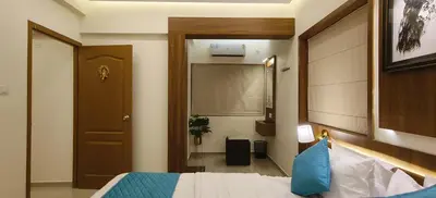 a hotel room with a bed and a door and a hallway at Radha Madhavam Apartment's in Guruvāyūr