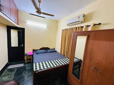 a small bedroom with a bed and a mirror at Bluebell Homes A - 3 BHK Near to Calicut in Beypore
