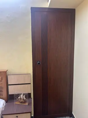 a wooden door in a bedroom with a wooden table at Bluebell Homes A - 3 BHK Near to Calicut in Beypore