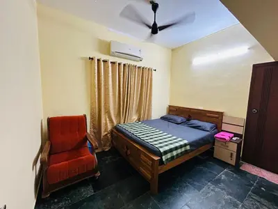 a bedroom with a bed and a chair at Bluebell Homes A - 3 BHK Near to Calicut in Beypore