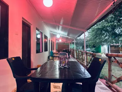 a black table and chairs on a porch with a table at The Big Cat's Den - Maravakandy Resort, Masinagudi in Masinagudi