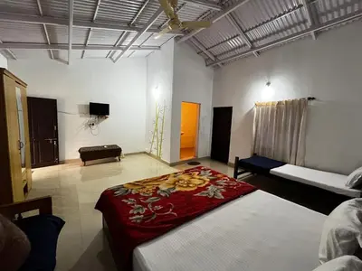 a room with two beds and a couch in it at The Big Cat's Den - Maravakandy Resort, Masinagudi in Masinagudi