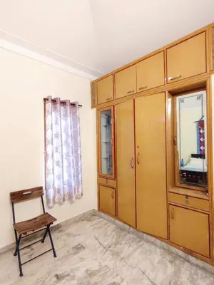 a room with a wooden cabinet and a chair at Spacious #3BHK Home Stay in Central Mysore in Mysore