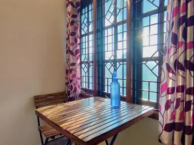 a blue bottle sitting on a wooden table in front of a window at Spacious #3BHK Home Stay in Central Mysore in Mysore