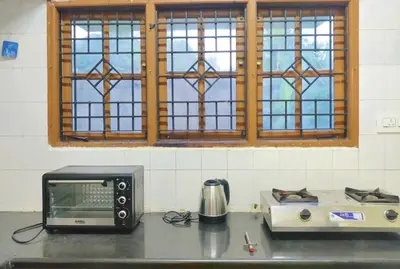 a microwave and a toaster oven on a kitchen counter at Spacious #3BHK Home Stay in Central Mysore in Mysore