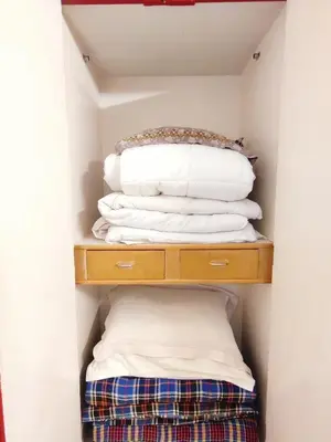 a stack of pillows on a shelf in a closet at Spacious #1BHK Home Stay in Central #Mysore in Mysore