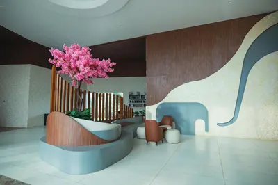 a lobby with a pink tree in a vase at Tuskers Hill Banquets by Poppys - Anaikatti in Palakkad