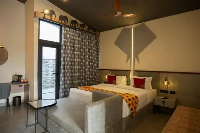 a bedroom with a bed and a large window at Tuskers Hill Banquets by Poppys - Anaikatti in Palakkad