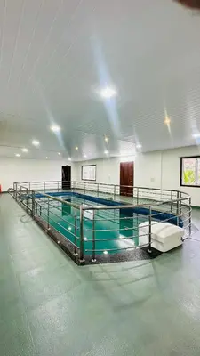 a swimming pool in a large room with water in it at Mountain Breeze Neyyans in Attappādi
