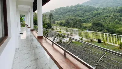 a balcony of a house with a view of a mountain at Mountain Breeze Neyyans in Attappādi