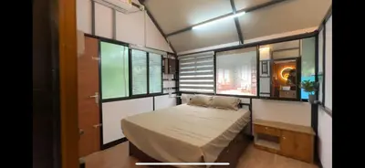 a small room with a bed and some windows at damora in Mannārakkāt