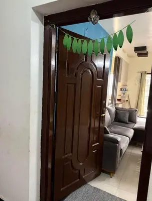 a brown door with green leaves on it in a living room at Spacious 3BHK Mountain View -walk to palani temple in Palani