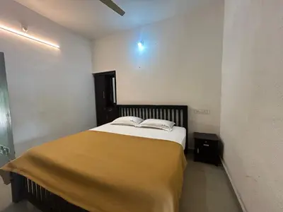 a bedroom with a bed with a yellow blanket on it at Le paradiso in Marayoor