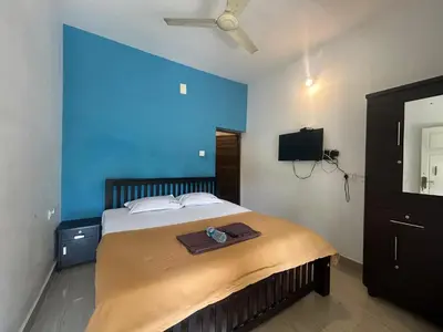 a bedroom with a large bed with a blue wall at Le paradiso in Marayoor