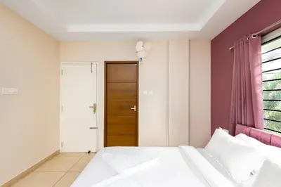 a bedroom with a bed and a wooden door at Simqo By Nexa Hotels Group in Kozhikode