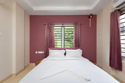 a bedroom with a large white bed in front of a window at Simqo By Nexa Hotels Group in Kozhikode