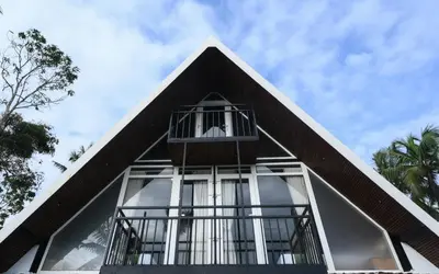 a pyramid shaped house with glass windows on top of it at Nirvana-Vadanappally Beach Villa in Irimbranallūr