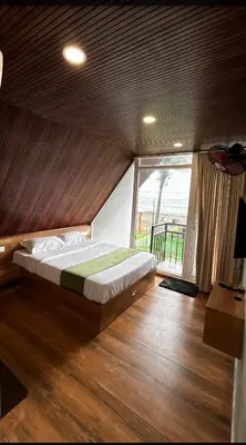 a bedroom with a bed and a large window at Nirvana-Vadanappally Beach Villa in Irimbranallūr