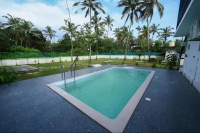 a swimming pool in the backyard of a house at Nirvana-Vadanappally Beach Villa in Irimbranallūr