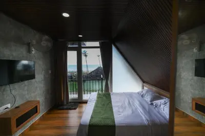 a bedroom with a large bed and a large window at Nirvana-Vadanappally Beach Villa in Irimbranallūr