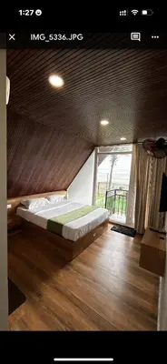 a bed in a room with a large window at Nirvana-Vadanappally Beach Villa in Irimbranallūr