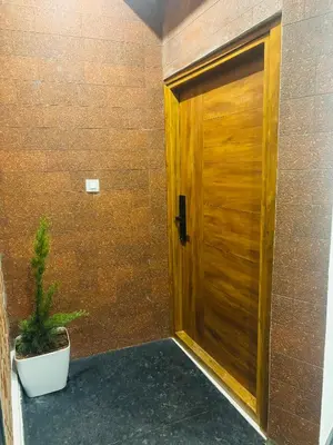 a wooden door in a room with a potted plant at Sihi Homes in Mysore