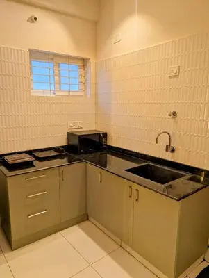 a kitchen with a sink and a counter top at Sihi Homes in Mysore