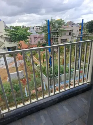 a railing on a balcony overlooking a city at Belaku in Chāmundi