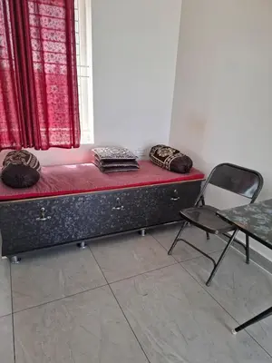 a bed in a room with a chair and a window at Belaku in Chāmundi