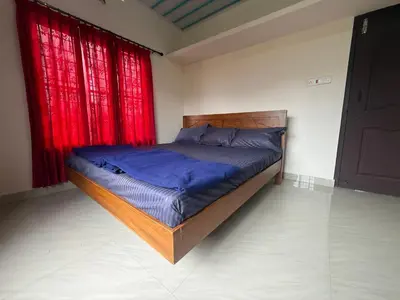 a bed in a bedroom with red curtains at Cosy Kalpetta Villa in Kalpetta
