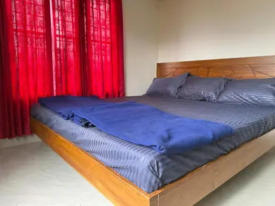 a bed in a bedroom with red curtains at Cosy Kalpetta Villa in Kalpetta