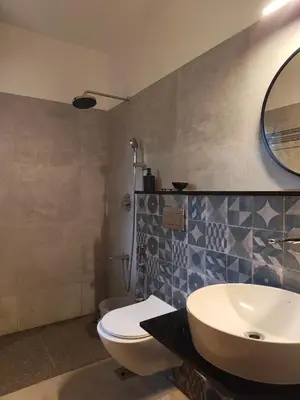 a bathroom with a sink and a toilet and a mirror at Birdwing - Experiential Farmstay Resort by GoodEarth