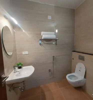 a bathroom with a sink and a toilet and a mirror at Elegant Residency in Coimbatore