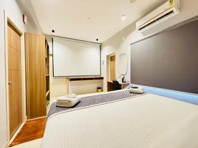 a room with a white bed and a projection screen at Elegant Residency in Coimbatore