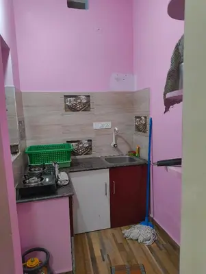 a small kitchen with a sink and a stove at Coorg Refresh Homestay in Kushālnagar