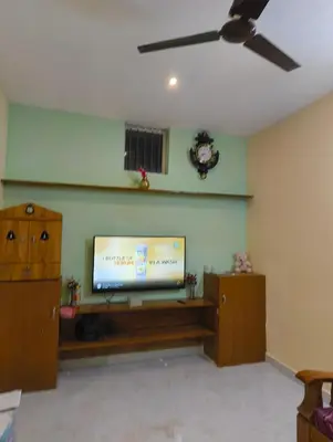 a living room with a flat screen tv on a wall at Coorg Refresh Homestay in Kushālnagar