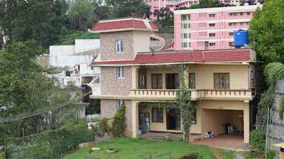 a house on the side of a hill at Happy Villa By Eden Luxury Stay in Ooty