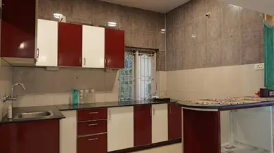a kitchen with red and white cabinets and a sink at Happy Villa By Eden Luxury Stay in Ooty