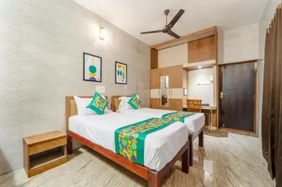 a bedroom with a large bed and a desk at Treebo Dunag in Coimbatore